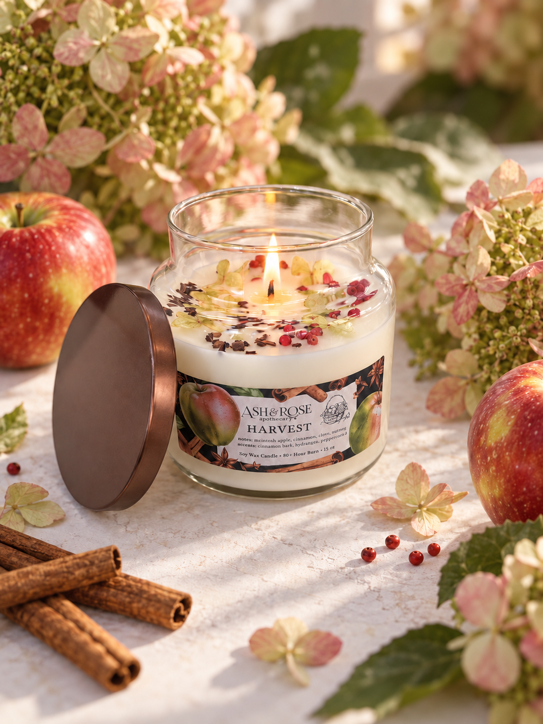 Overhead view of the HARVEST apothecary jar candle topped with hydrangea petals, pink peppercorns and clove